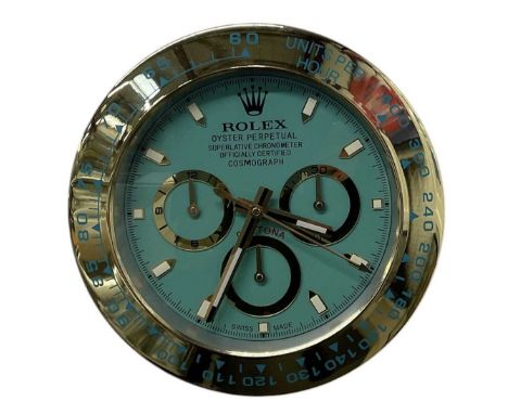 A decorative Rolex Daytona Cosmograph style dealer's wall clock, the turquoise dial set with subsidiary seconds and inscribed