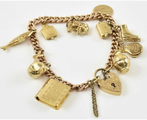 A 9ct yellow gold charm bracelet with eleven charms including elephant, hot water bottle, fish, bible etc, united with a 9ct 