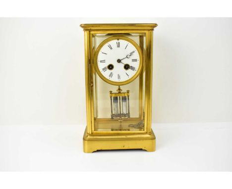 A large French brass cased table clock, with four bevelled glass panels, the white enamel dial set with Roman numerals, outer