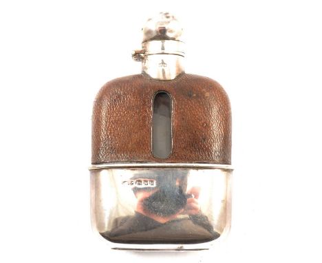 A small silver hip flask, the glass flask covered in leather to the top with a detachable silver cup to base, London 1928, W&