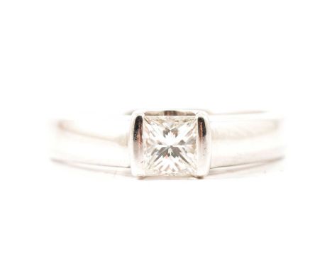 A princess cut diamond solitaire ring, the 4.6mm square stone bar set to each side in a platinum mount, with 4mm wide polishe