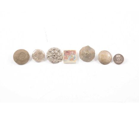 A collection of loose buttons, buckles, coins, badges, some early examples, printing blocks, a military brass button cleaning