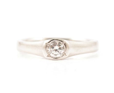 A diamond solitaire ring, the brilliant cut stone collet set in a platinum mount with 3.3mm wide polished shoulders, ring siz