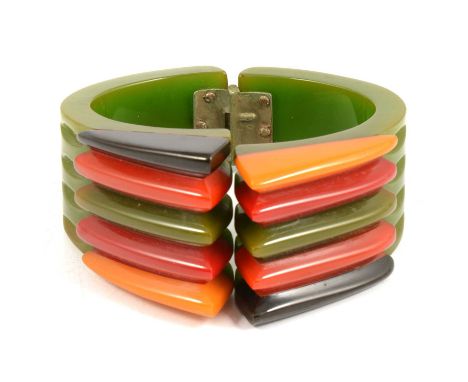 A 1930's Art Deco "Philadelphia" Bangle, the green hinged clamper cuff supporting black, orange, green, red and yellow fins, 