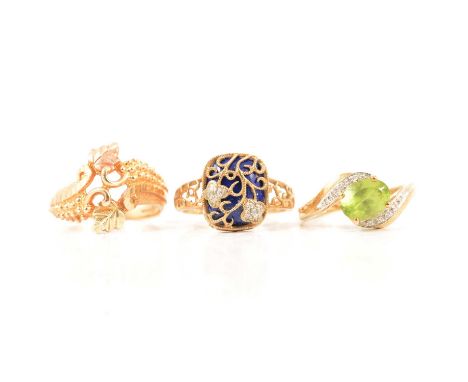 Three dress rings, a 9 carat yellow and rose gold leaf and tendril ring size Q, 4.7g; a peridot and diamond dress ring, the o