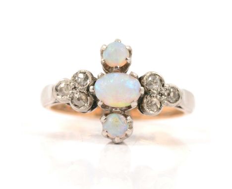 An opal and diamond ring, three cabochon cut opals claw set vertically and flanked by a trefoil of three old 8 cut diamonds m