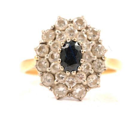A sapphire and diamond oval cluster ring, the oval mixed cut sapphire 6 x 4mm, claw set and surrounded by twenty-four brillia