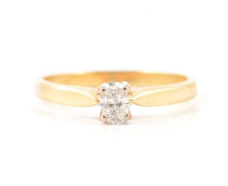 A diamond solitaire ring, the oval brilliant cut stone four claw set in an 18 carat yellow and white gold mount ring size O, 