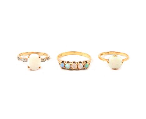 Three opal dress rings, an opal solitaire ring, the cushion cabochon cut opal eight claw set in a yellow metal mount marked 1