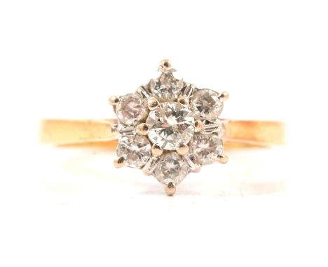 A diamond cluster ring, seven brilliant cut diamonds claw set in an 18 carat yellow and white gold floral cluster mount, 9.8m