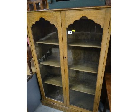 A vintage oak two-door glazed bookcase together with a small oak nursing chair with Art Nouveau tapestry seat & back