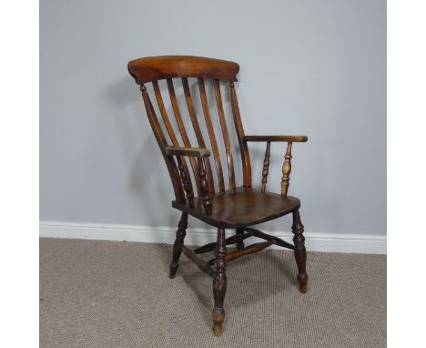 An antique stained ash and elm Windsor stick back elbow Chair, raised on turned legs and stretchers, W 62 cm x H 113 cm x D 7