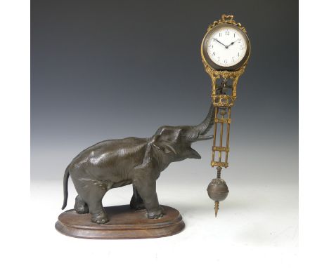 A Continental Gilt Brass and Bronzed Spelter "Mystery" Timepiece, modelled in the form of an elephant with raised trunk holdi