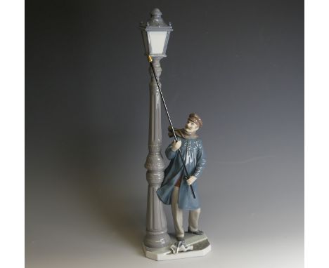 A Lladro porcelain model of a Lamplighter, modelled with figure holding a torch toward the lamp, H 47cm. 
