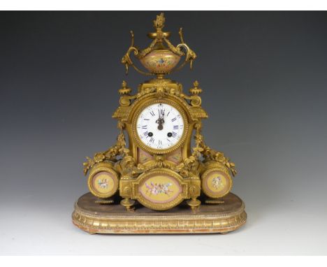 A mid-19th century French ormolu and porcelain mounted Mantel Clock, surmounted with a twin handled urn, the white enamel dia