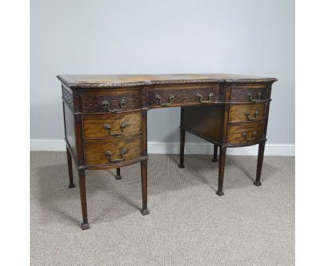 An early 20thC walnut writing Desk circa 1920's, with an inverted serpentine front above single drawer over kneehole, flanked