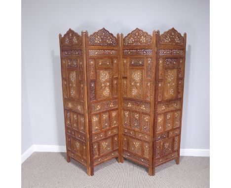 A Moroccan style pierced wood four panel folding screen, circa 1960, W 50.5 cm x H 186 cm x D 2.5 cm. 