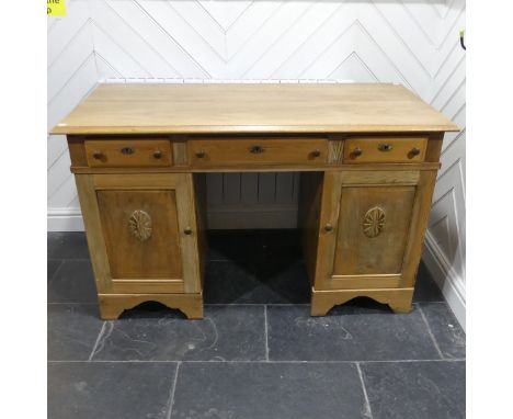 An Antique bleached oak pedestal Desk, rectangular top above three frieze drawers, central drawer above kneehole, flanked by 