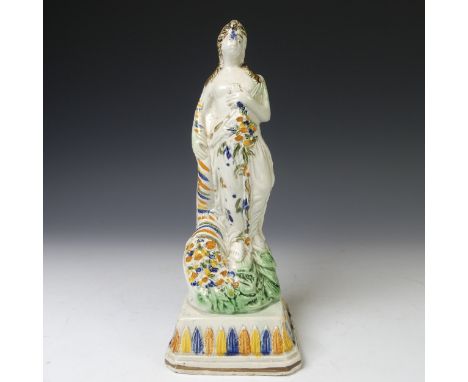 An early 19thC prattware figure of Flora, or the season of Spring, depicted wearing classical drapery, with flora at waist he