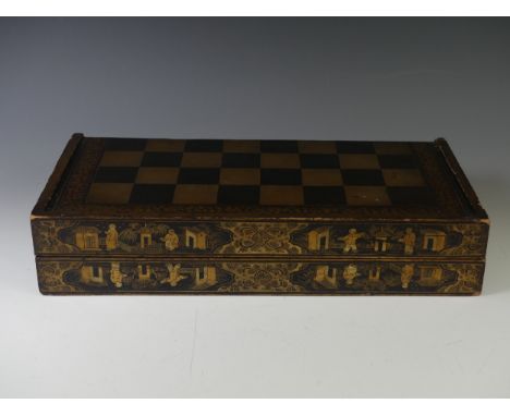 An early 19thC Chinese export lacquer rectangular games box, decorated in gilt with a chess board, the sides with vignettes, 