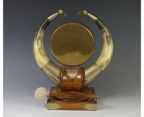 An Edwardian oak and Horn dinner Gong, the central brass gong supported by two horns mounted upon an oak base, W 26 cm x H 31