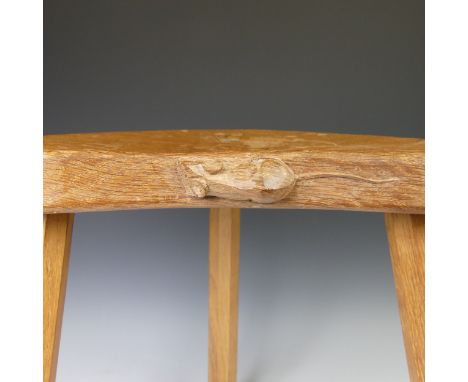 Workshop of Robert Mouseman Thompson (Kilburn): An English Oak Kidney Shaped Calf Stool, on three octagonal legs, with carved