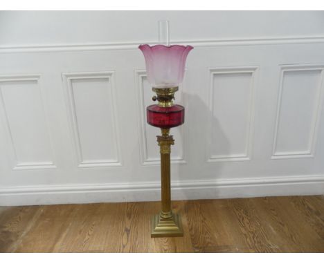 A Victorian brass and cranberry glass Oil Lamp,&nbsp;bearing TRS mark, the stepped base with corinthian column stem below cra