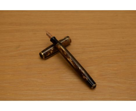 A Parker Royal Challenger Standard button fill fountain pen in brown and honey striated marble with black chevron pattern wit