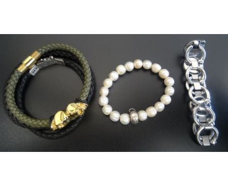FIVE DESIGNER BRACELETScomprising a Northskull London twin skull bracelet on green woven leather; a Thomas Sabo Charm Club pe
