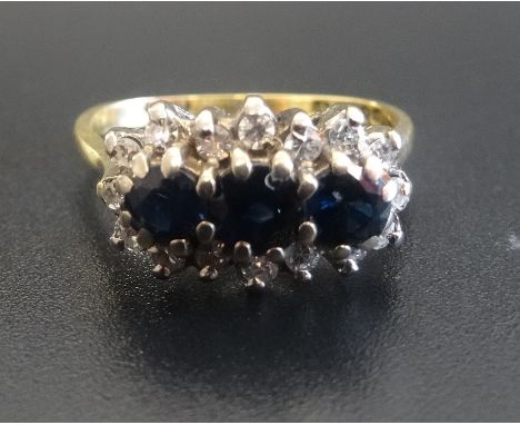 SAPPHIRE AND DIAMOND CLUSTER RINGthe three central sapphires in sixteen diamond surround, on eighteen carat gold shank, ring 