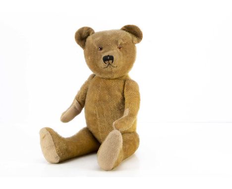 A 1930's Teddy Bear possibly  French, with short golden mohair, orange and black glass eyes, black stitched nose, swivel head