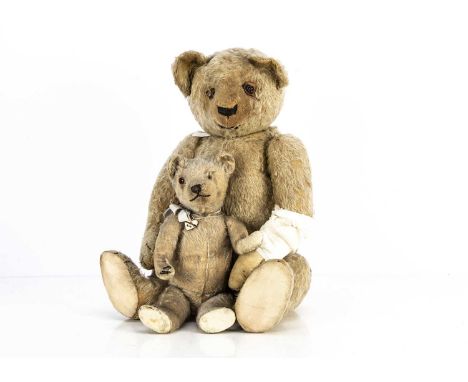 Two late 1920's British Teddy Bears,  the smaller with blonde mohair, orange and black glass eye (one missing), swivel head a