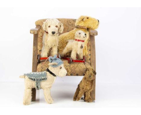 Five British soft toy dogs,  two post-war Chiltern dogs on red painted metal framed wheels —11 1/4in. (29cm.) length of large