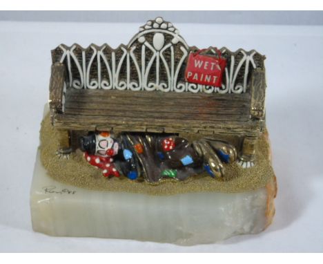 Cast bronze cold painted clown under a bench on an onyx base signed Ron '85 with hand signed signature to the rear