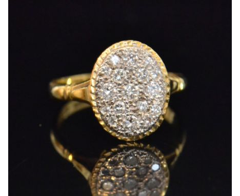 A late 20th Century 18ct diamond ring, the oval head millegrain set with seventeen brilliant cut diamonds within yellow gold 