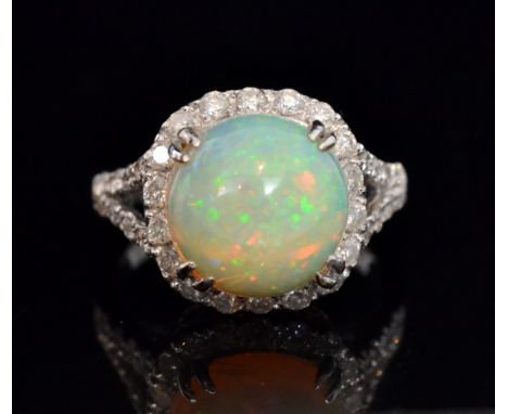 A 18ct hallmarked white gold opal and diamond cluster ring, central circular cabochon claw set opal, weight approximately 3.5