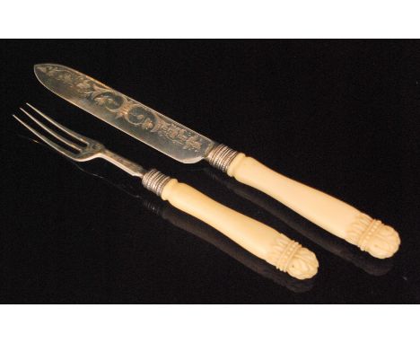 A hallmarked silver and ivory cake knife and fork with foliate engraved decoration to blades and stiff leaf carved detail to 