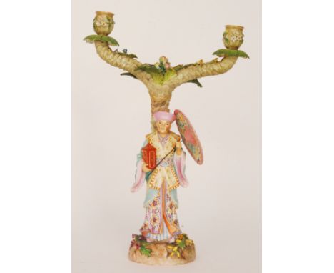 A 19th Century Rudolstadt twin branch candelabra modelled with an Oriental man stood holding a lantern and parasol and dresse