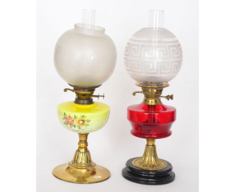 A Victorian brass oil lamp painted yellow reservoir below an acid etched shade, height 50cm, together with a similar brass oi