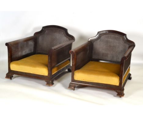 A pair of mahogany framed double cane bergere easy chairs with blind fret and floral carving on ogee bracket feet (2)