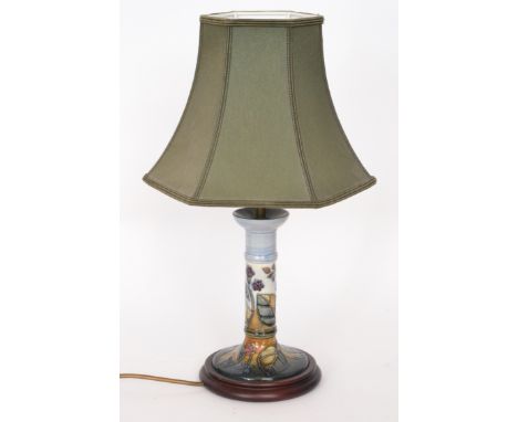 A Moorcroft Pottery table lamp, the pedestal base decorated with blackberries and foliage to a pale blue ground, marks obscur