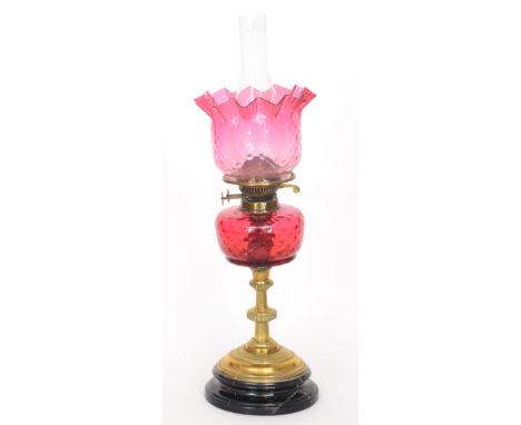 A Victorian brass oil lamp with ruby shade reservoir and chimney, height 52cm, S/D to base.