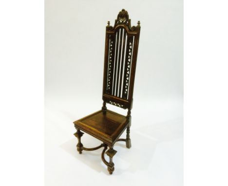 An oak high back hall chair, with foliate scrolls flanking the lath back above the plain seat panel and turned legs united by