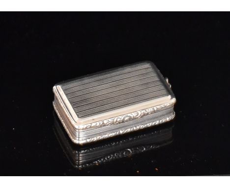A George III hallmarked silver snuff box of rectangular form with reeded decoration and chased foliate borders and thumb piec