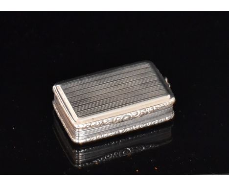 A George III hallmarked silver snuff box of rectangular form with reeded decoration and chased foliate borders and thumb piec