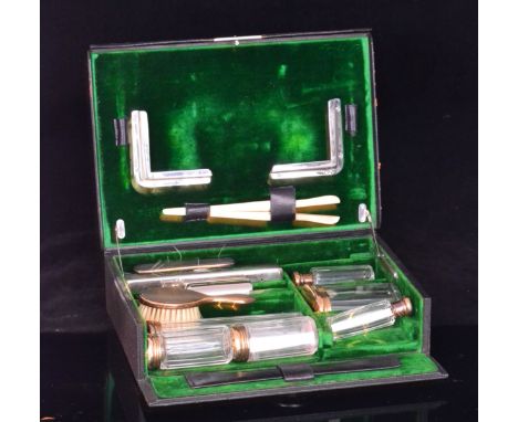 A George V ladies travelling dressing set, comprising of six hallmarked silver topped toilet jars, two silver backed brushes,