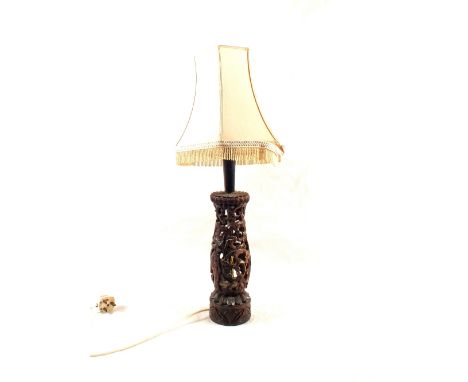 An Indonesian carved hardwood reticulated figure decorated table lamp