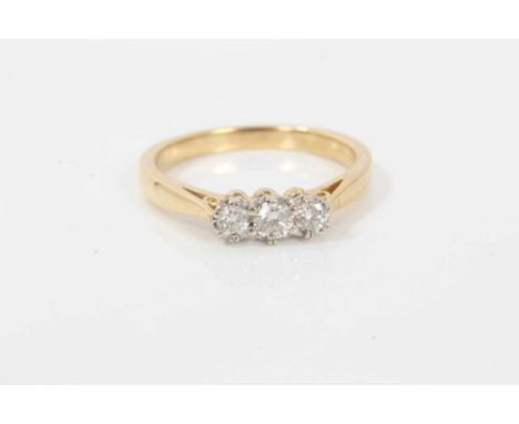 Diamond three stone ring with three brilliant cut diamonds in claw setting on 18ct yellow gold shank. Estimated total diamond