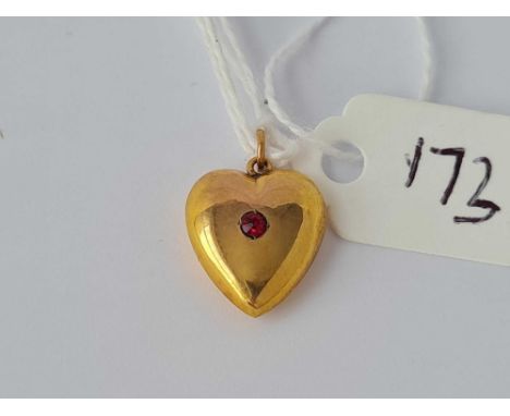 A heart shaped pendant set with a ruby 