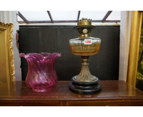 A Victorian brass oil lamp, with cranberry glass shade, height excluding chimney 48cm.&nbsp; 